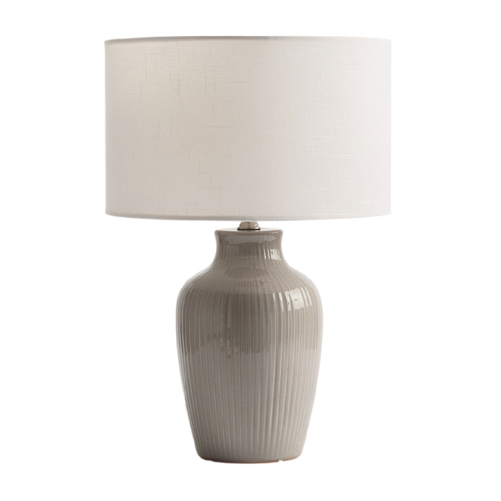 Lampe de table en céramique gris avec abat-jour en tissu blanc.